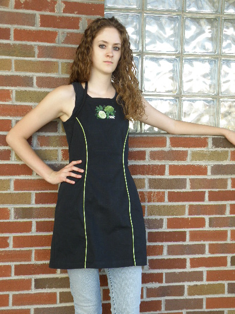 Women's Bib apron style W740; Shown in black, 100% cotton Ripstop with Lime piping along princess seams, & embroidered Lime Botanical on center chest.