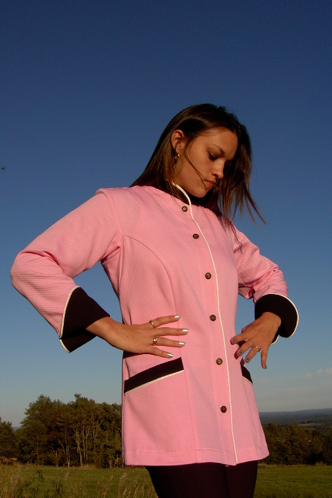 Women's Chef Coat Style BSW103: Shown in pink & black, 100% cotton petti point pique, ivory piping (collar, front, cuffs & pockets) two front hip tailored welt pockets, & metal on black horn horse head buttons.