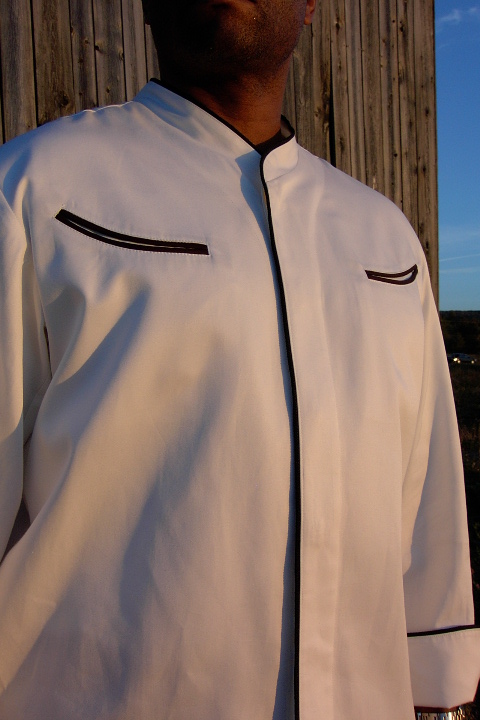 Chef Coat Style CBM103H: Shown in white, 100% cotton Supima® gabardine, left & right chest curved double welt pockets, & black piping (collar, front, pocket & cuffs).