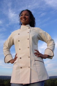 Women's Chef Coat Style BSW101: Shown in Natural, 100% Combed Cotton Ripstop, date piping (collar, pockets & cuffs), two front hip tailored welt pockets & tiger shell buttons.