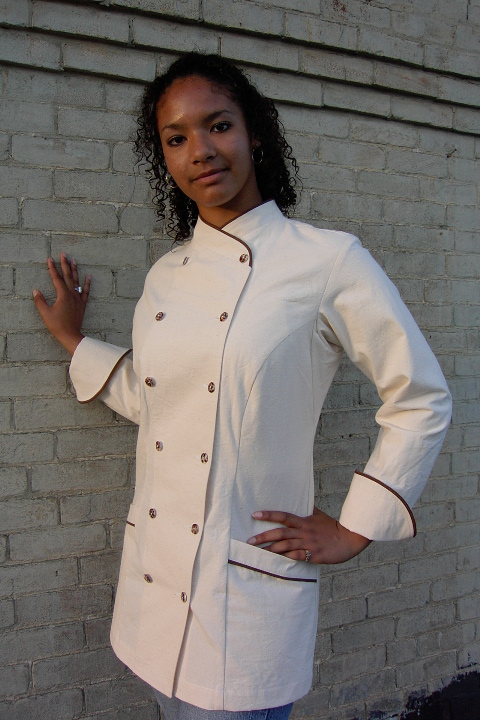 Women's Chef Coat Style BSW101: Shown in Natural, 100% Combed Cotton Ripstop, date piping (collar, pockets & cuffs), two front hip tailored welt pockets & tiger shell buttons.