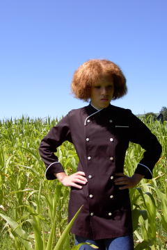 Women's Chef Coat Style CBW101: Shown in Black, 100% Cotton Supima® gabardine, natural white piping (collar, pocket & cuffs), left chest tailored welt pocket & faux mother-of-pearl buttons.