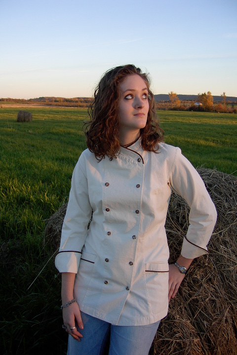 Women's Chef Coat Style BSW101: Shown in Natural, 100% Combed Cotton Ripstop, date piping (collar, pockets & cuffs), two front hip tailored welt pockets & tiger shell buttons.
