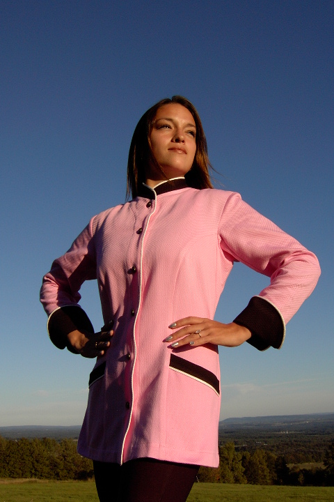 Women's Chef Coat Style BSW103: Shown in pink & black, 100% cotton petti point pique, ivory piping (collar, front, cuffs & pockets) two front hip tailored welt pockets, & metal on black horn horse head buttons.