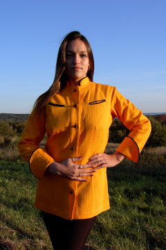 Women's Chef Coat Style BSW104: Shown in orange, 100% cotton honeycomb pique, left & right chest curved double welt pockets, black piping (collar, cuffs & pockets) & hand tied knot buttons.