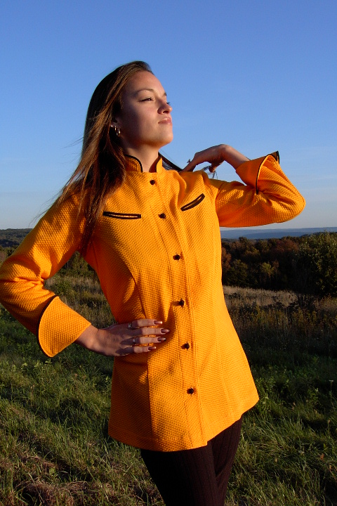 Women's Chef Coat Style BSW104: Shown in orange, 100% cotton honeycomb pique, left & right chest curved double welt pockets, black piping (collar, cuffs & pockets) & hand tied knot buttons.