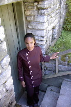 Women's Chef Coat Style CBW105: Shown in Black, 100% cotton gabardine, with a left sleeve tailored welt pocket, Pink Sham piping (cuffs, collar & front) & faux Mother-of-Pearl buttons.