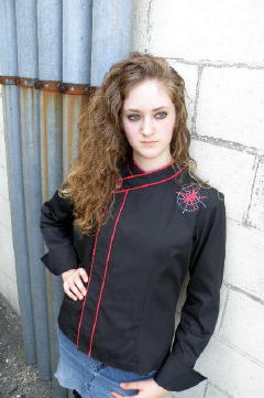 Cropped Women's Jacket Style CBW105H; Shown in black 100% cotton Supima® Gabardine with two rows of Foxy Red piping along the collar and placket, one red tagua nut top button, spider embroidery on left front shoulder and square cuffs.